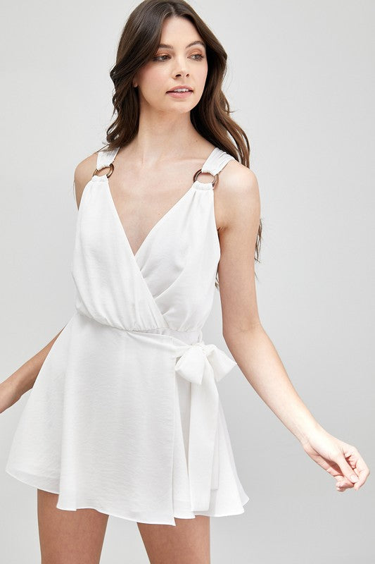 A woman in a sleeveless Trim Detail Side Tie Romper gazes to the side, showcasing a versatile wardrobe addition.