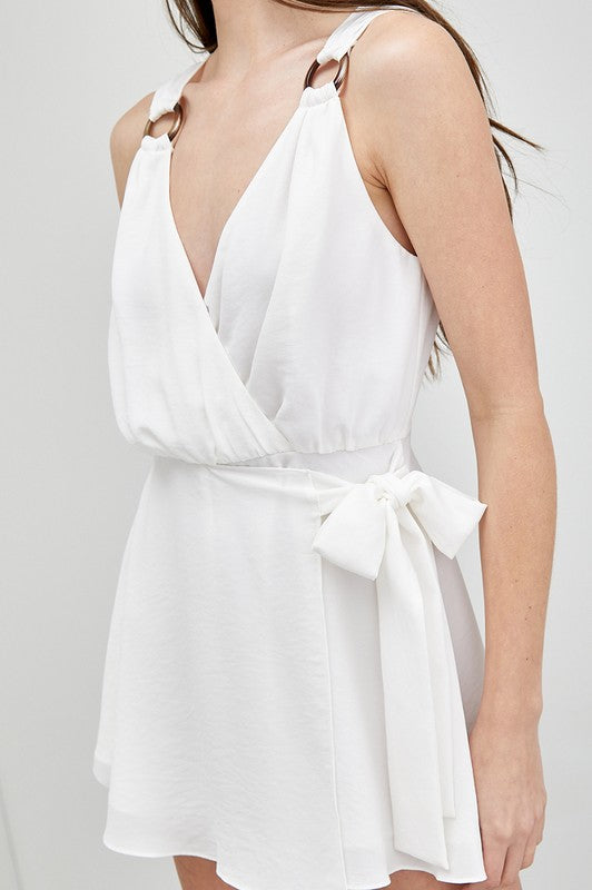 A woman in a sleeveless Trim Detail Side Tie Romper gazes to the side, showcasing a versatile wardrobe addition.