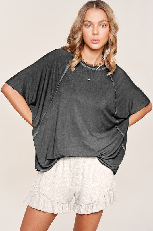 Wearing Joyce Shorts made from cream-colored cotton fabric, paired with brown boots, perfect for a casual wardrobe ensemble.