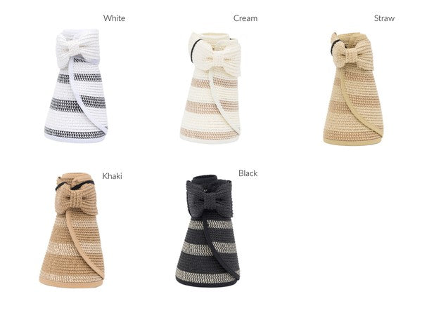 Woman in a white bikini holding her Marled Stripe Roll up Bow Visor while facing the sea.