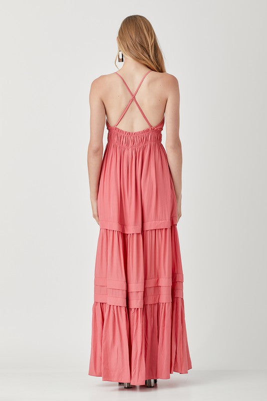 Dressed in a Shirred Ruffle Folded Detail Maxi Dress, featuring a striking blue color, plunging neckline, and stylish ruffle accents, the individual stands against a plain background exuding an effortless boho style.