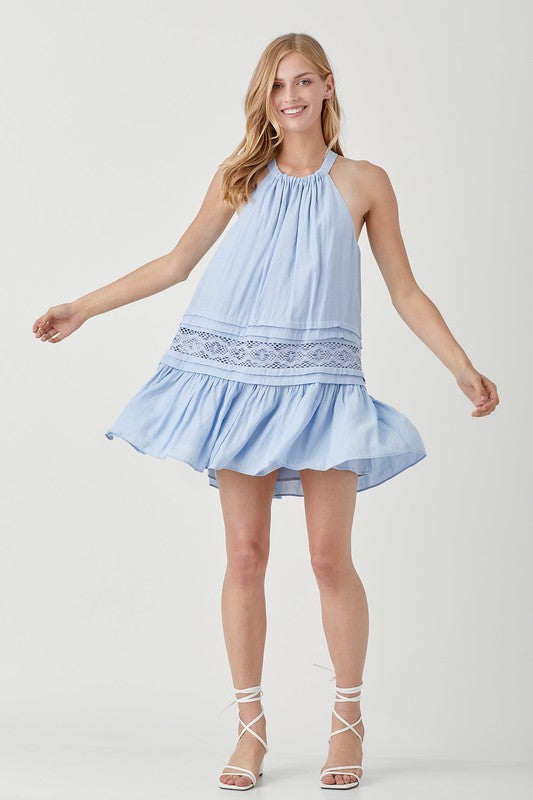 A woman wearing the Halter Neck Trim Lace with Folded Detail Dress in light blue, stands against a plain background.