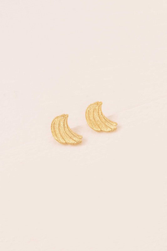 Six pairs of Banana Earrings, crafted in a blend of sterling silver with gold and rose gold accents, are arranged in a neat line on a light background. This collection adds a touch of quirky jewelry charm to any ensemble.