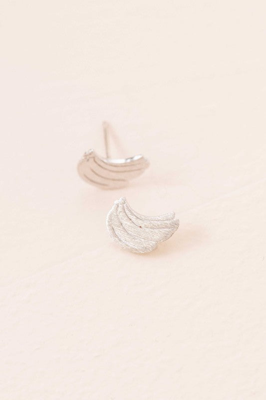 Six pairs of Banana Earrings, crafted in a blend of sterling silver with gold and rose gold accents, are arranged in a neat line on a light background. This collection adds a touch of quirky jewelry charm to any ensemble.