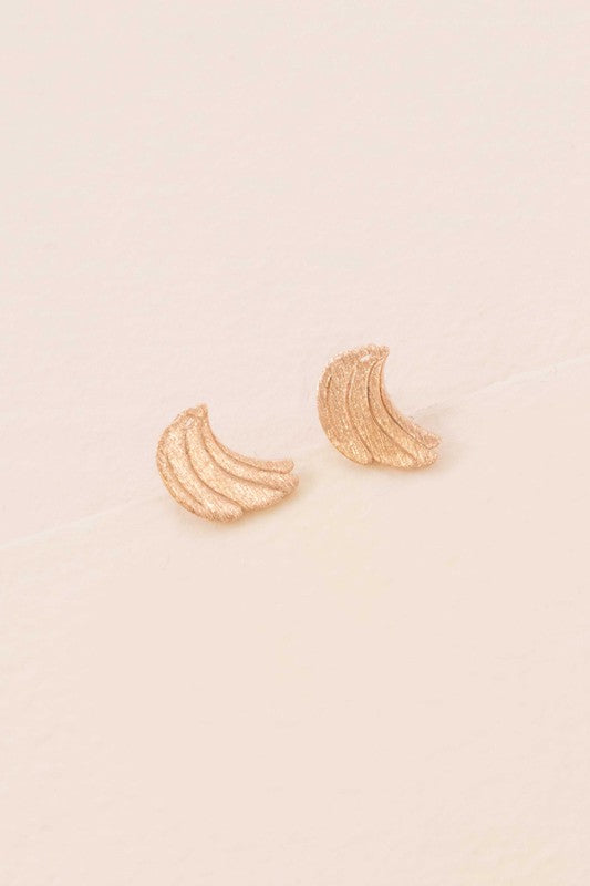 Six pairs of Banana Earrings, crafted in a blend of sterling silver with gold and rose gold accents, are arranged in a neat line on a light background. This collection adds a touch of quirky jewelry charm to any ensemble.