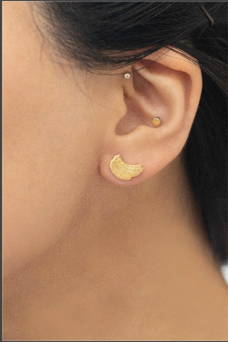 Six pairs of Banana Earrings, crafted in a blend of sterling silver with gold and rose gold accents, are arranged in a neat line on a light background. This collection adds a touch of quirky jewelry charm to any ensemble.