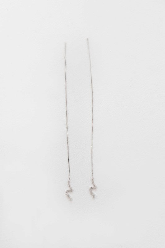 Scribble Threader Earrings made of long, thin sterling silver with a snake-like design displayed against a white background.