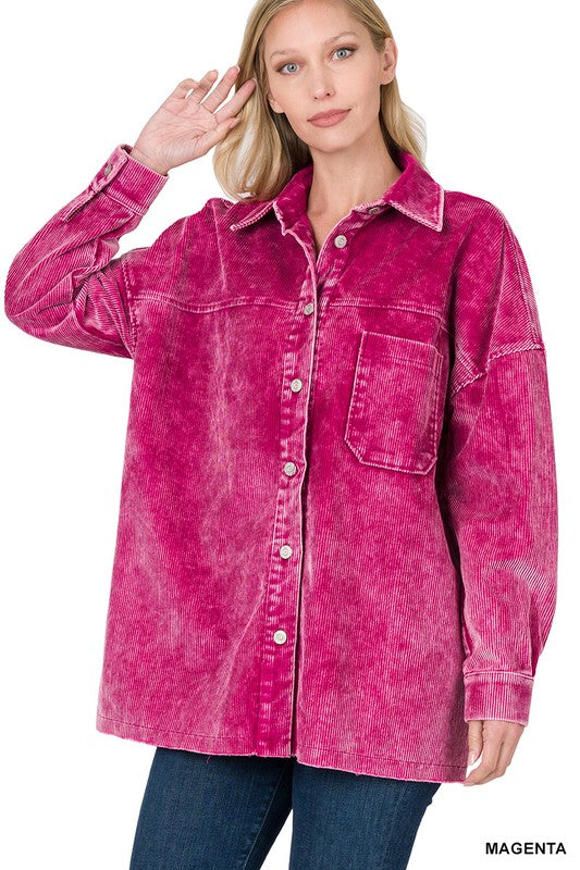 A person stands wearing an Oversized Premium Vintage Washed Corduroy Shacket in magenta, featuring a button-up design and one front pocket, paired with dark jeans.