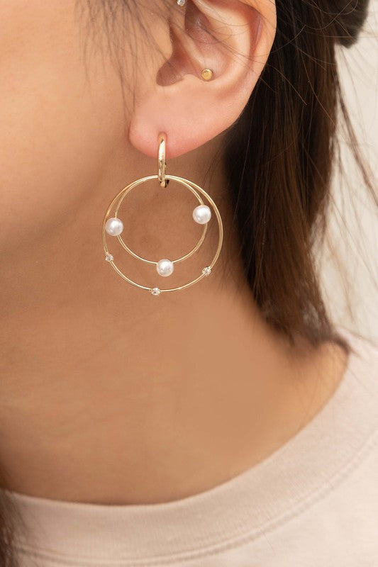 The Fawn Pearl Hoop Earrings, elegantly enhanced with pearls, gleam on a pristine white background, featuring lustrous 10k gold plating.