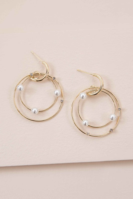 The Fawn Pearl Hoop Earrings, elegantly enhanced with pearls, gleam on a pristine white background, featuring lustrous 10k gold plating.