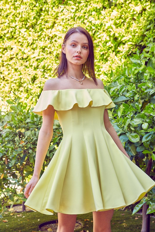 A woman in the quintessential A Line Ruffle Dress poses by a pool, the dress's flattering fit accentuated by the vibrant greenery in the background.