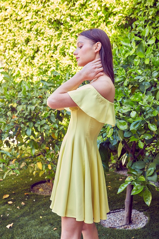 A woman in the quintessential A Line Ruffle Dress poses by a pool, the dress's flattering fit accentuated by the vibrant greenery in the background.