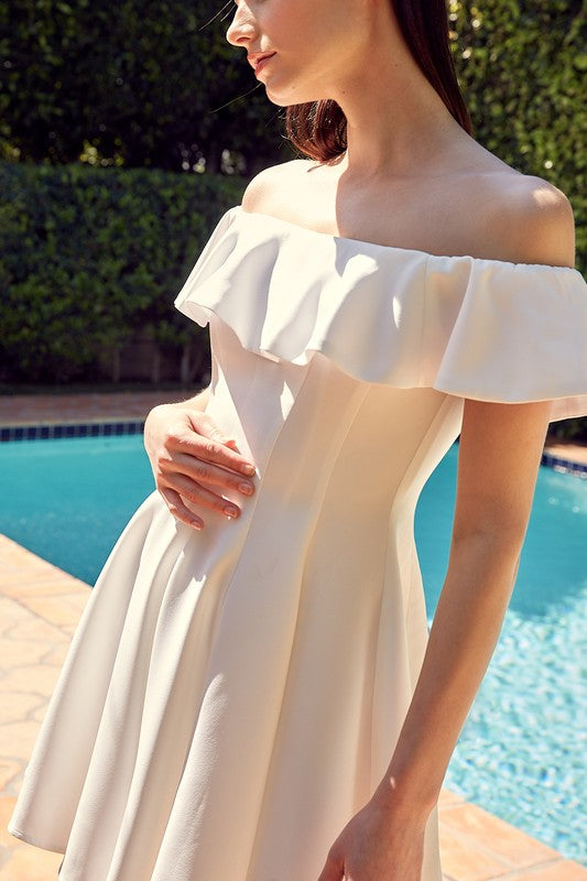 A woman in the quintessential A Line Ruffle Dress poses by a pool, the dress's flattering fit accentuated by the vibrant greenery in the background.