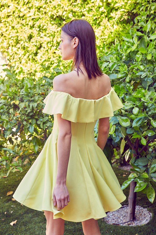 A woman in the quintessential A Line Ruffle Dress poses by a pool, the dress's flattering fit accentuated by the vibrant greenery in the background.