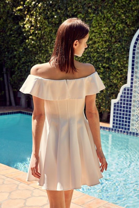 A woman in the quintessential A Line Ruffle Dress poses by a pool, the dress's flattering fit accentuated by the vibrant greenery in the background.