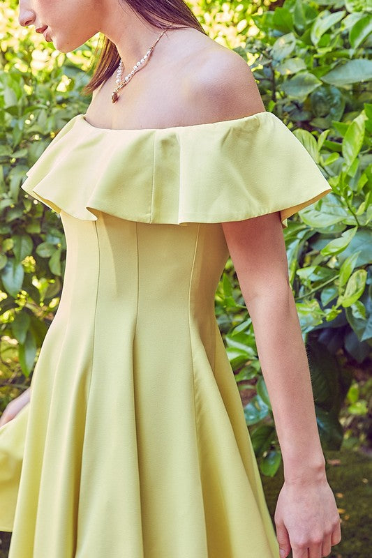 A woman in the quintessential A Line Ruffle Dress poses by a pool, the dress's flattering fit accentuated by the vibrant greenery in the background.