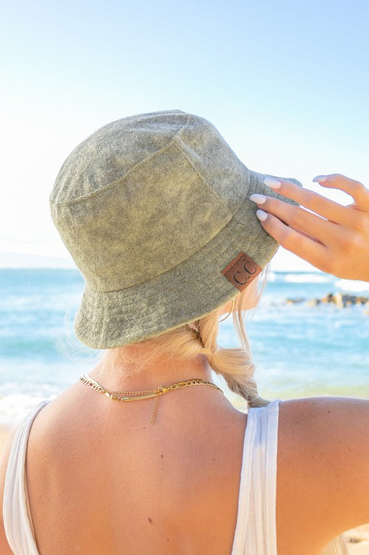 Woman wearing a CC Terry Cloth Bucket Hat and sunglasses at the beach.