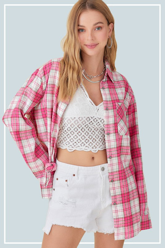 A woman wearing the Dreamy Shirt, a pink plaid print top, over a white crochet crop top and white distressed shorts, standing against a light gray background.
