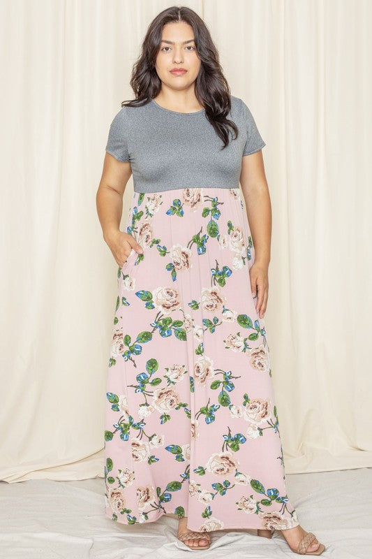 A woman in a short sleeve floral maxi dress, crafted from lightweight polyester spandex fabric, stands against a cream backdrop.