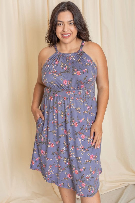 Wearing the elegant Plus Floral Halter Top Midi Dress, a person stands in front of a beige curtain, smiling with eyes closed. Crafted with care, this stunning piece is proudly made in the United States.