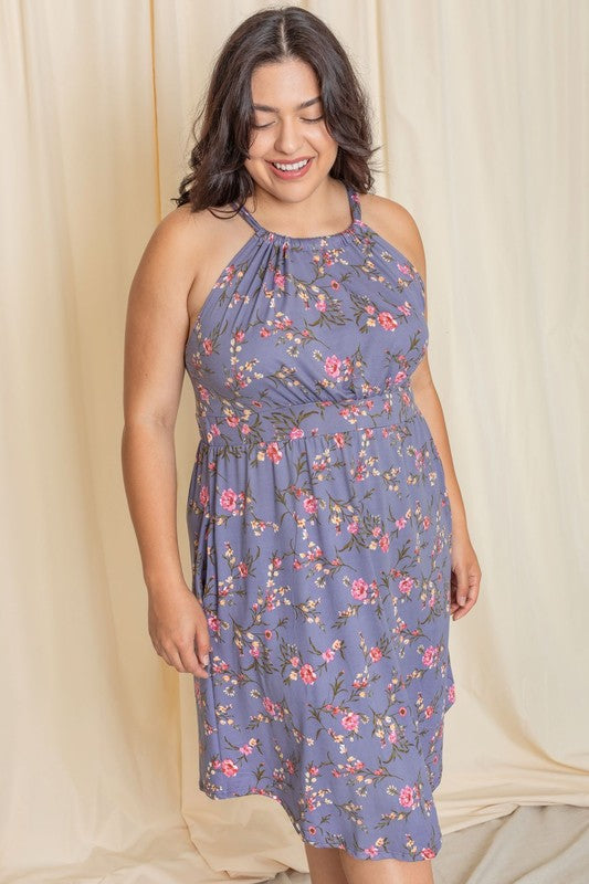 Wearing the elegant Plus Floral Halter Top Midi Dress, a person stands in front of a beige curtain, smiling with eyes closed. Crafted with care, this stunning piece is proudly made in the United States.