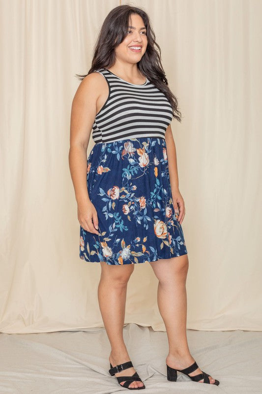 In the United States, a person poses in the Stripe Sleeveless Mini Dress, which features a black and gray striped top combined with a vibrant blue floral skirt.