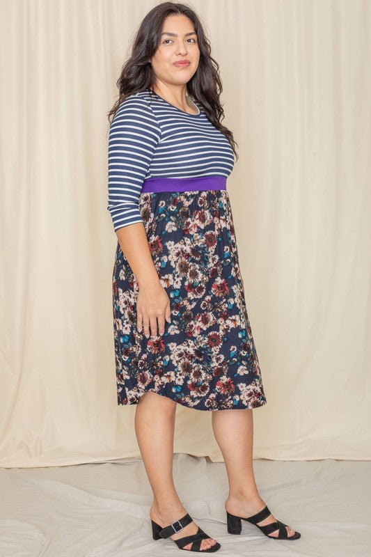 A woman wearing a Floral Band Midi Dress grins joyfully while standing in front of a beige curtain.