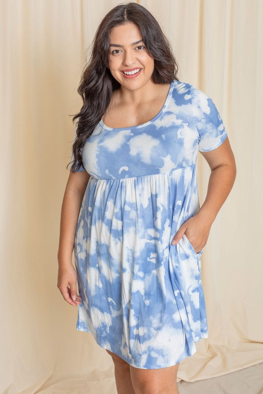 A person elegantly poses in front of a cream-colored curtain, dressed in the Plus Cloud Tie Dye Midi Dress made from soft polyester.