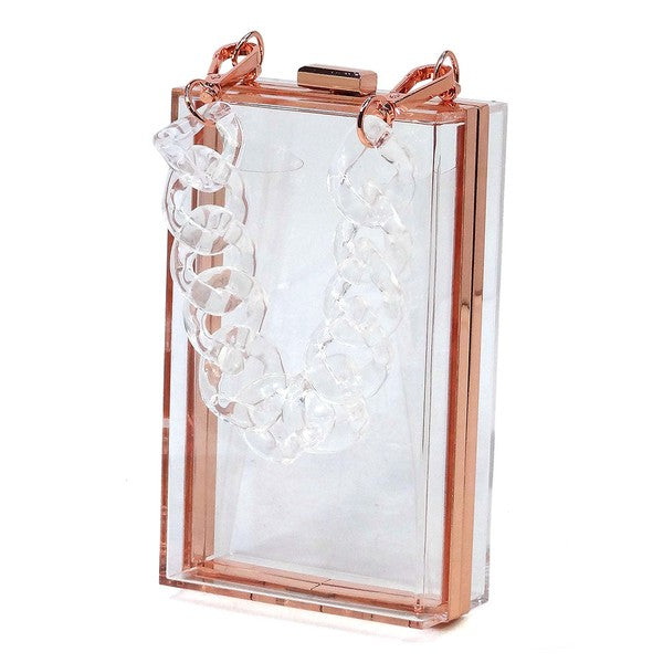 The Acrylic Chain Handle See Thru Crossbody Clutch is a rectangular pink acrylic crossbody clutch that features a sleek gold chain strap and a detachable shoulder chain, highlighted by an elegant pink acrylic chain handle.