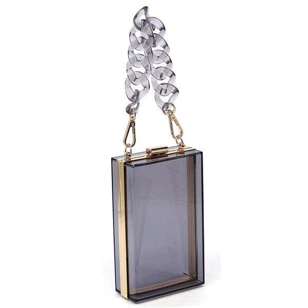 The Acrylic Chain Handle See Thru Crossbody Clutch is a rectangular pink acrylic crossbody clutch that features a sleek gold chain strap and a detachable shoulder chain, highlighted by an elegant pink acrylic chain handle.