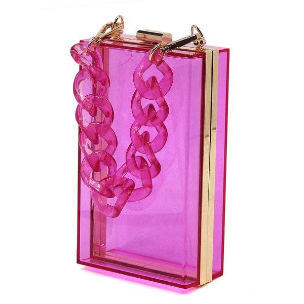 The Acrylic Chain Handle See Thru Crossbody Clutch is a rectangular pink acrylic crossbody clutch that features a sleek gold chain strap and a detachable shoulder chain, highlighted by an elegant pink acrylic chain handle.