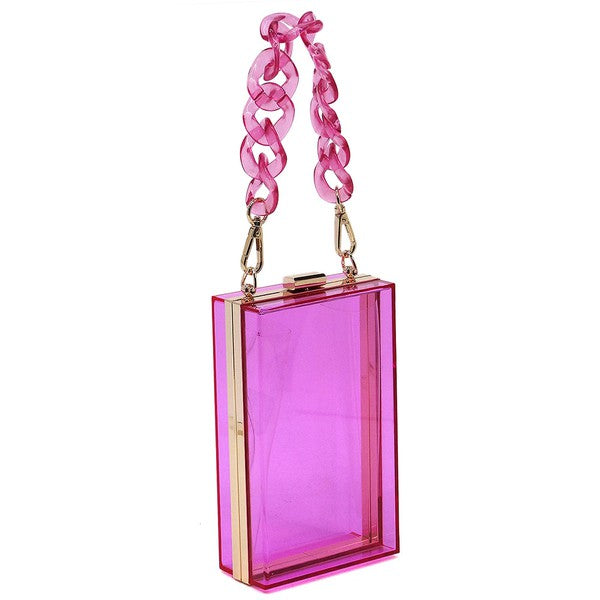 The Acrylic Chain Handle See Thru Crossbody Clutch is a rectangular pink acrylic crossbody clutch that features a sleek gold chain strap and a detachable shoulder chain, highlighted by an elegant pink acrylic chain handle.