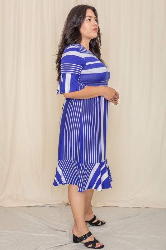 A person wearing a Plus Mix Stripe Ruffle Midi Dress stands against a beige background, smiling.