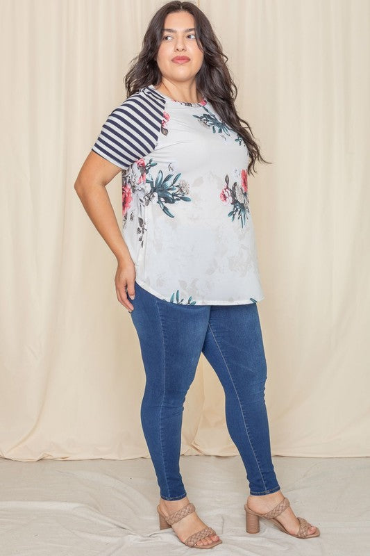 Wearing a Plus stripe sleeve floral top/tunic, a person smiles against a light background.