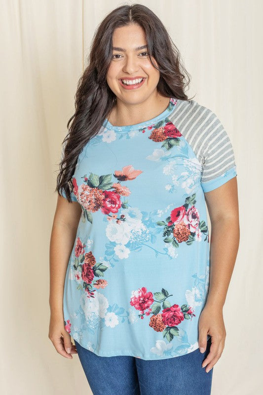 Wearing a Plus stripe sleeve floral top/tunic, a person smiles against a light background.