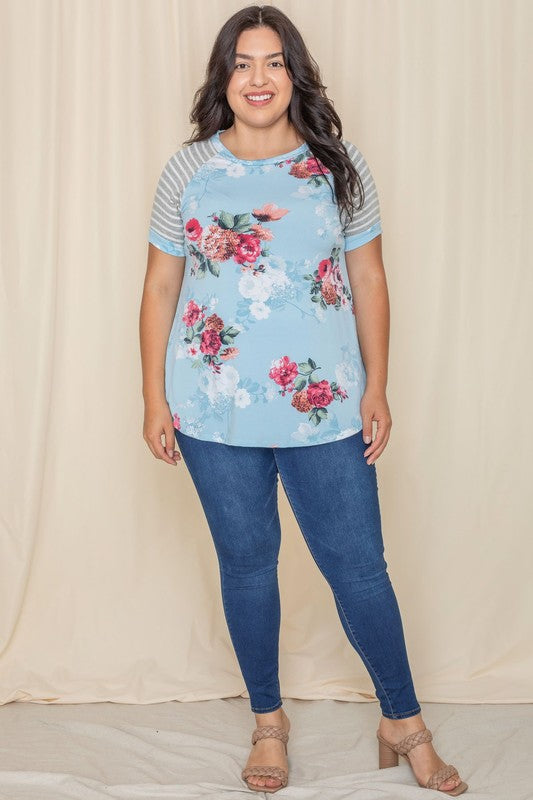 Wearing a Plus stripe sleeve floral top/tunic, a person smiles against a light background.