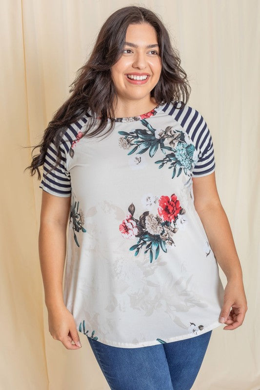 Wearing a Plus stripe sleeve floral top/tunic, a person smiles against a light background.