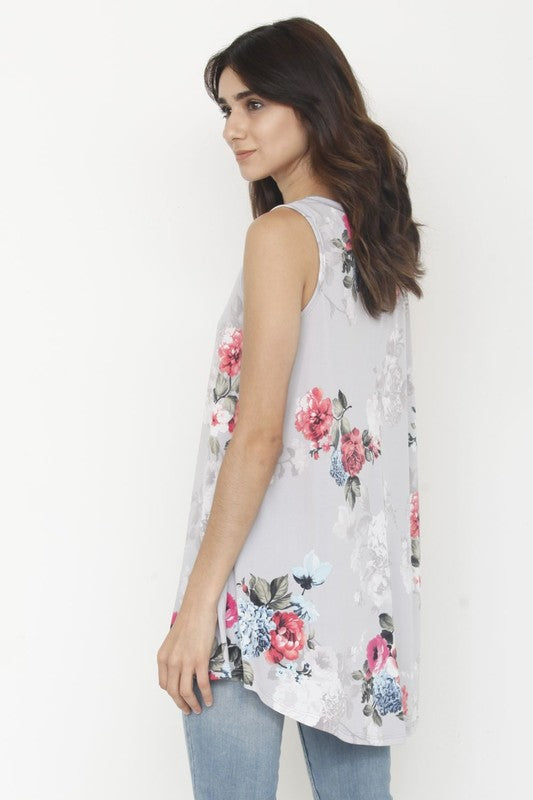 A woman dressed in a floral tunic crafted from polyester spandex fabric, paired with white shorts, stands against a plain background.