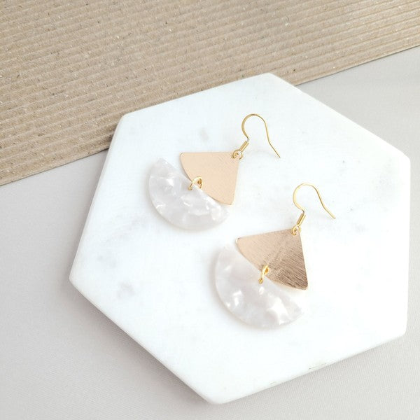 The Ava Pearl Earrings, crafted with 18K gold-plated details, gleam brilliantly on a hexagonal marble backdrop.