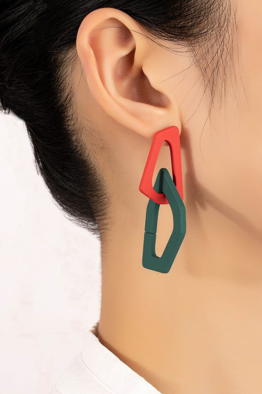 Close-up of lightweight acrylic earrings named "Organic Shape Chunky Link Drop Earrings," featuring interlocking triangular shapes in beige and gray, displayed on a flat surface.