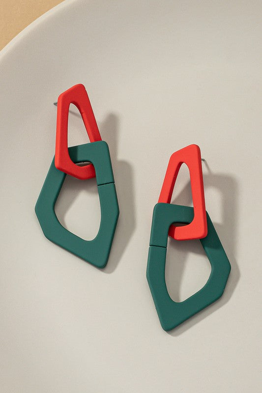 Close-up of lightweight acrylic earrings named "Organic Shape Chunky Link Drop Earrings," featuring interlocking triangular shapes in beige and gray, displayed on a flat surface.