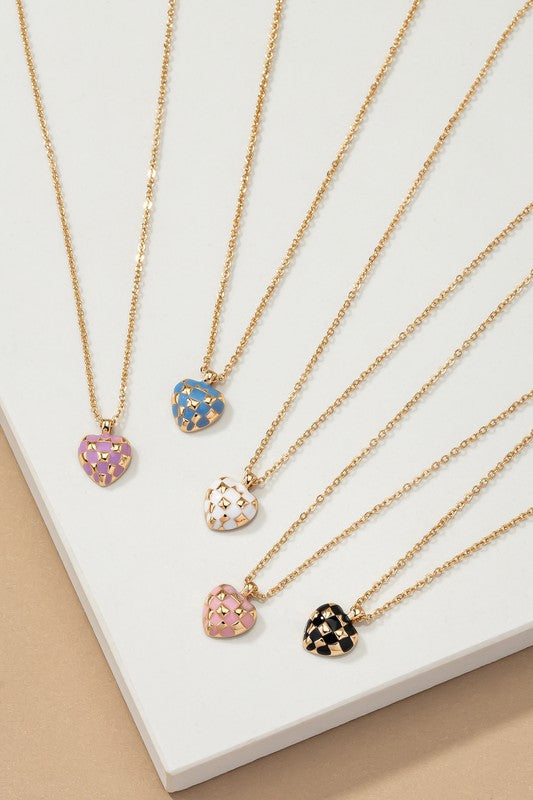 Introducing the Checker Heart Pendant Necklace: A collection of five necklaces showcasing a chic style with heart-shaped pendants. Each pendant features elegant enamel designs in pink, blue, white, and black on a beige background, adding a touch of sophistication to your ensemble.