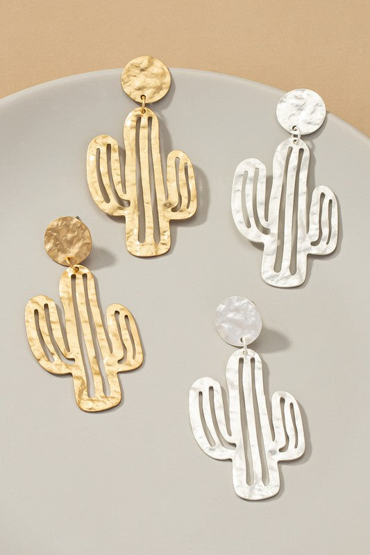 Four pairs of hammered thin metal openwork cactus drop earrings, two in matte gold and two in silver, elegantly arranged on a neutral surface.