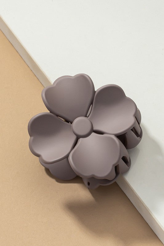 An elegant display of Matte Color Coated Flower Hair Claw Clips in soft Morandi shades is beautifully organized on a beige surface, creating a peaceful and fashionable look.