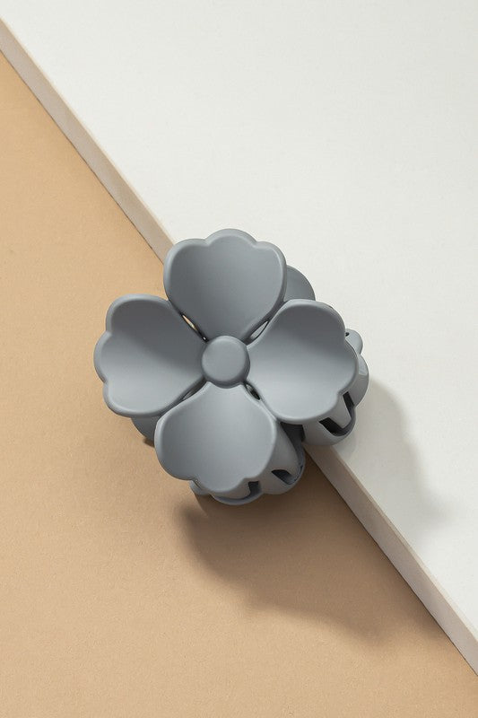 An elegant display of Matte Color Coated Flower Hair Claw Clips in soft Morandi shades is beautifully organized on a beige surface, creating a peaceful and fashionable look.