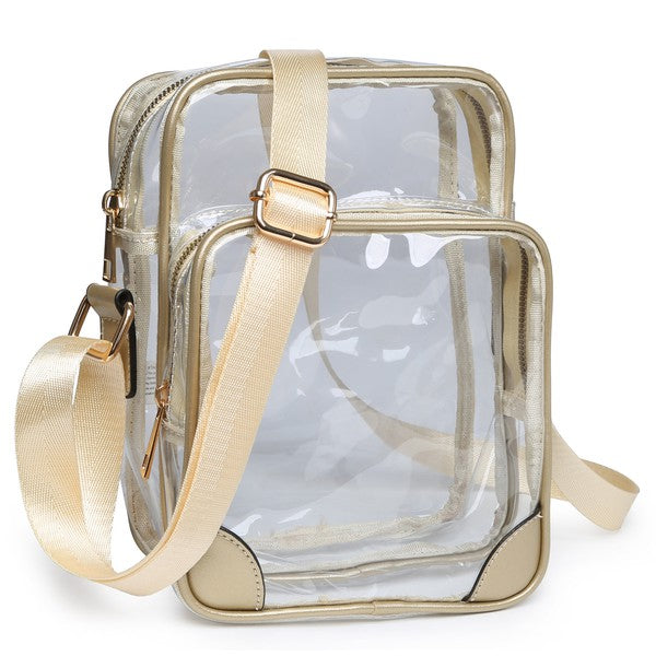 The See Thru Multi Compartment Crossbody Bag is a small, clear rectangular crossbody bag with blue trim and an adjustable blue shoulder strap. Made from faux leather, it features gold zipper closures on two compartments.