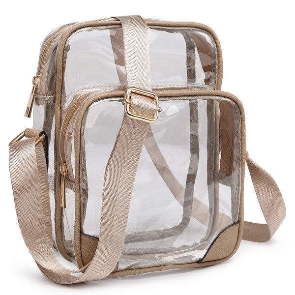 The See Thru Multi Compartment Crossbody Bag is a small, clear rectangular crossbody bag with blue trim and an adjustable blue shoulder strap. Made from faux leather, it features gold zipper closures on two compartments.