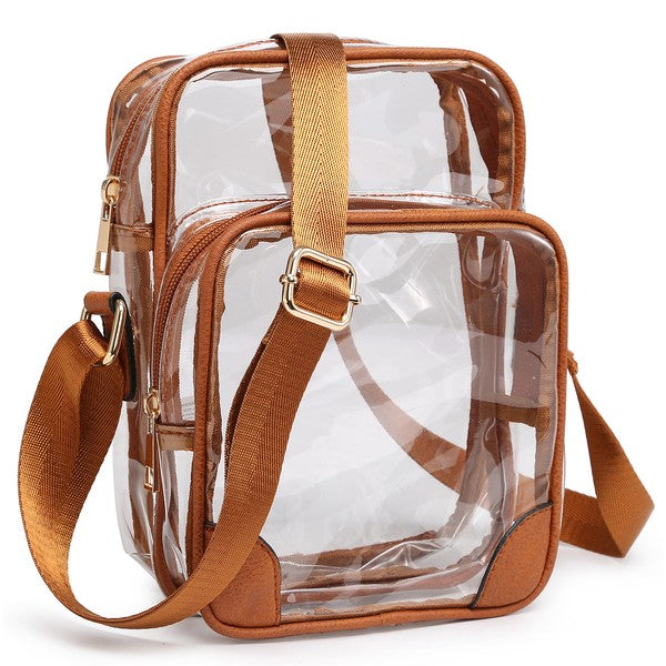 The See Thru Multi Compartment Crossbody Bag is a small, clear rectangular crossbody bag with blue trim and an adjustable blue shoulder strap. Made from faux leather, it features gold zipper closures on two compartments.