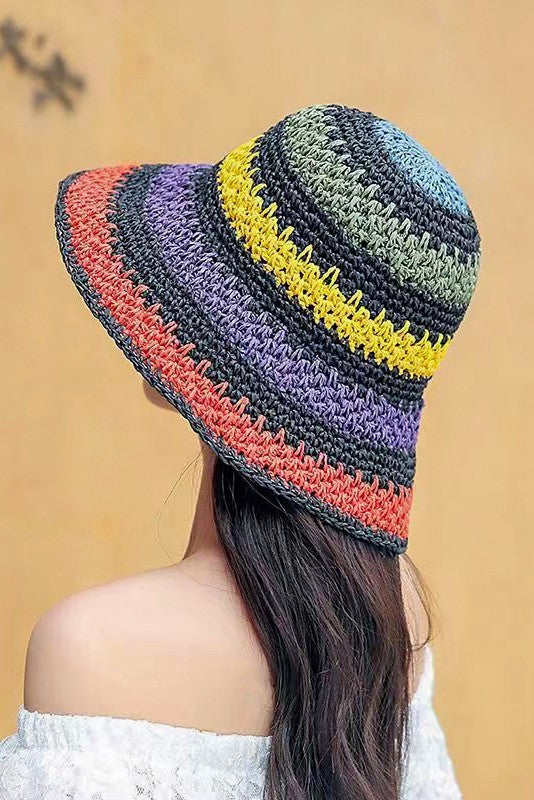 Three vibrant Packable crochet straw bucket hats with multi-color stripes are stacked elegantly on a plain background.