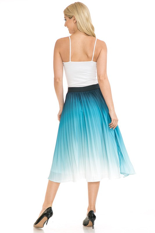 A woman with long blonde hair wears a black sleeveless top paired with the Women's High Waist Pleated A-Line Swing skirt featuring a purple to white gradient pleat and black ballet flats. She poses with one arm slightly bent and the other at her side.